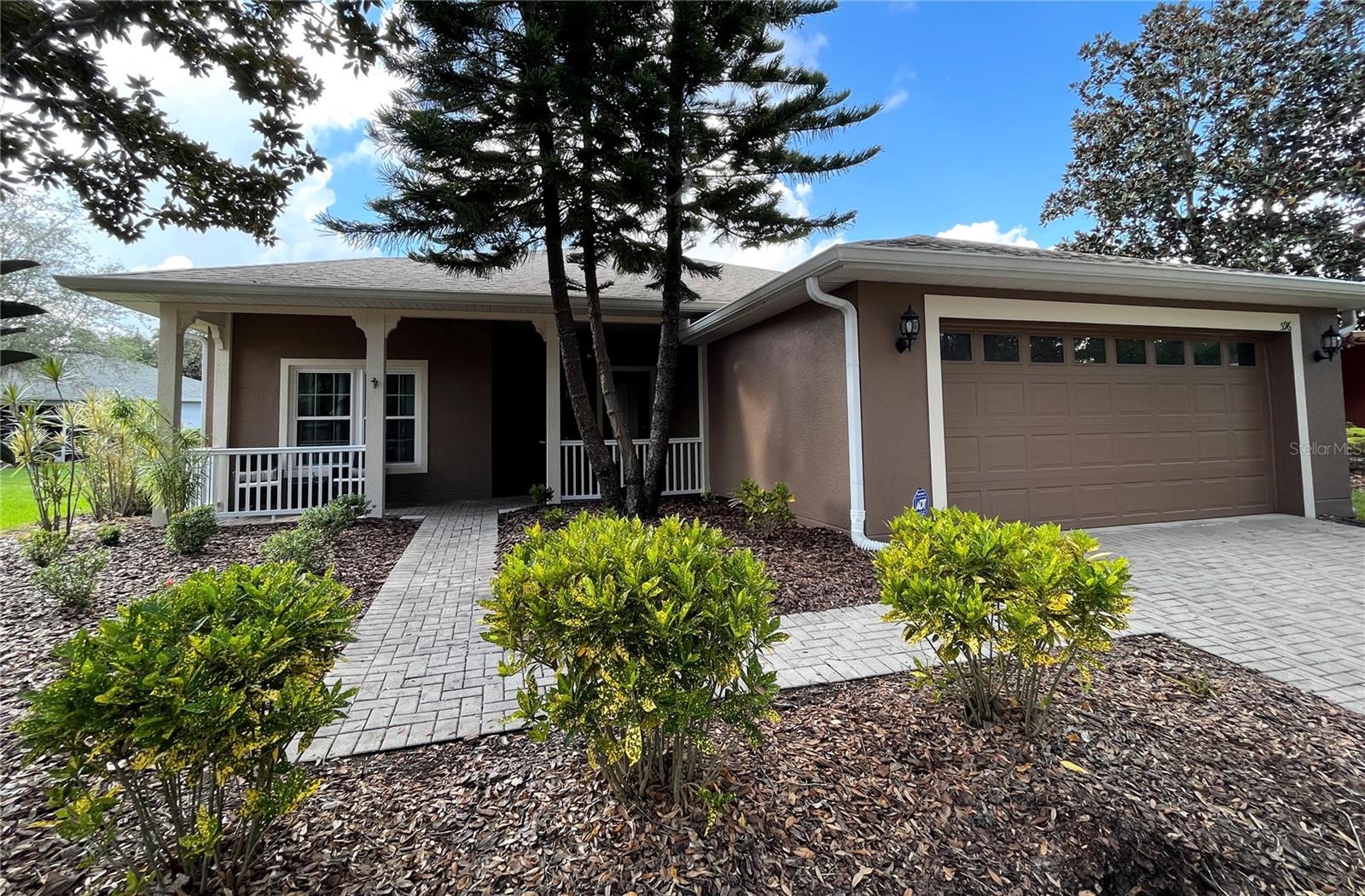 A house with a driveway and trees in front of it